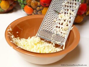 Grating frozen butter into a bowl
